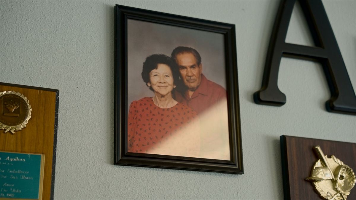 Framed family portrait on the wall of the Vista office, beside the Aguilera's “A” logo